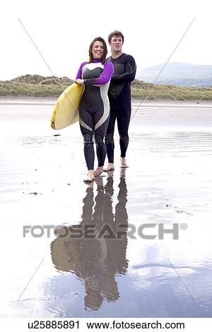 Portrait of couple with surfboard on beach View Large Photo Image Stock Image - Portrait of couple with surfboard on beach. Fotosearch