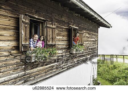 Portrait of family at chalet windows, Achenkirch, Tyrol, Austria View Large Photo Image Picture - Portrait of family at chalet windows, Achenkirch, Tyrol, Austria. Fotosearch