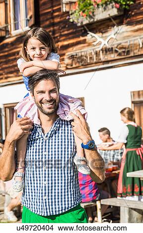 Picture - Portrait of father and daughter outside chalet, Tyrol, Austria. Fotosearch