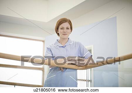 Portrait of female nurse in hospital atrium View Large Photo Image Stock Photograph - Portrait of female nurse in hospital atrium. Fotosearch