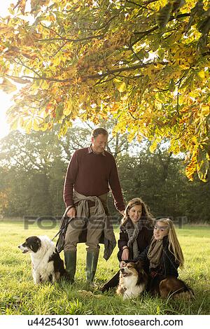 Stock Image - Portrait of grandparents and granddaughter with dogs, Norfolk, UK. Fotosearch