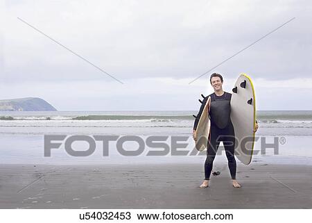 Portrait of man with surfboards on beach View Large Photo Image Stock Image - Portrait of man with surfboards on beach. Fotosearch