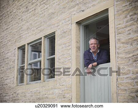 Portrait of mature farmer looking out from farmhouse door View Large Photo Image Stock Image - Portrait of mature farmer looking out from farmhouse door. Fotosearch