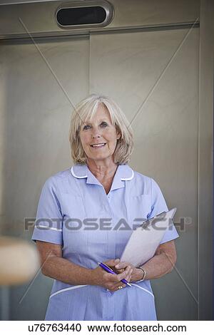 Portrait of mature female nurse in hospital corridor View Large Photo Image Stock Image - Portrait of mature female nurse in hospital corridor. Fotosearch