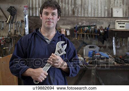 Portrait of mature man holding wrench in boat workshop View Large Photo Image Picture - Portrait of mature man holding wrench in boat workshop. Fotosearch