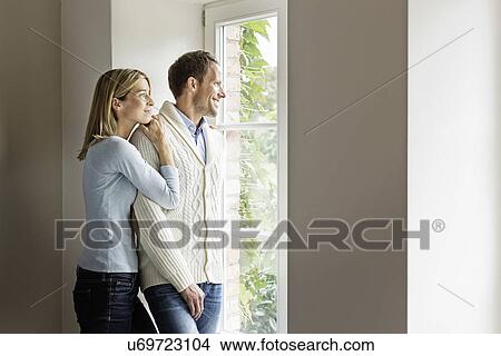 Portrait of mid adult couple looking out of window View Large Photo Image Picture - Portrait of mid adult couple looking out of window. Fotosearch