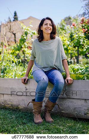 Stock Photo - Portrait of mid adult woman in garden. Fotosearch