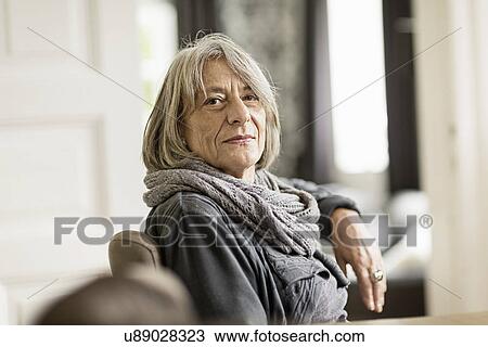 Stock Image - Portrait of senior woman with grey hair wearing scarf. Fotosearch