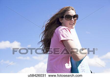 Stock Image - Portrait of teenager, blue sky. Fotosearch