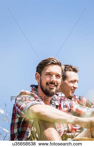 Stock Photo - Portrait of two young men against blue sky. Fotosearch