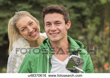 Stock Photograph - Portrait of young couple sitting on vespa. Fotosearch