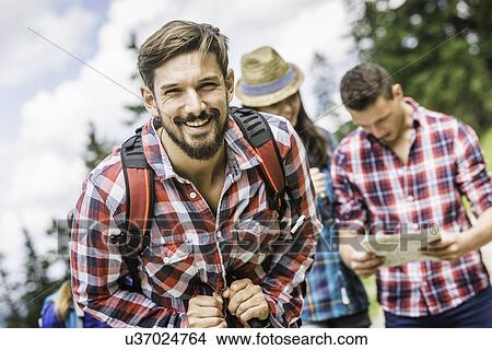 Picture - Portrait of young man wearing checked shirt, smiling. Fotosearch