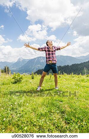 Portrait of young man with arms out, Tyrol, Austria View Large Photo Image Stock Photograph - Portrait of young man with arms out, Tyrol, Austria. Fotosearch
