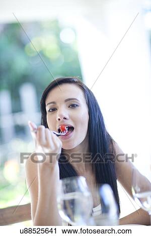 Portrait of young woman eating View Large Photo Image Stock Image - Portrait of young woman eating. Fotosearch