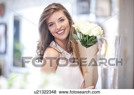 Stock Photo - Portrait of young woman holding bunch of roses. Fotosearch