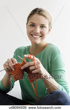 Stock Photo - Portrait of young woman knitting. Fotosearch
