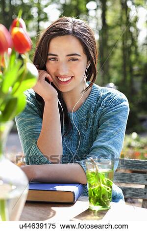 Portrait of young woman listening to earphones View Large Photo Image Stock Photography - Portrait of young woman listening to earphones. Fotosearch