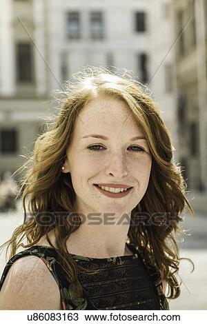 Portrait of young woman standing in town View Large Photo Image Stock Image - Portrait of young woman standing in town. Fotosearch