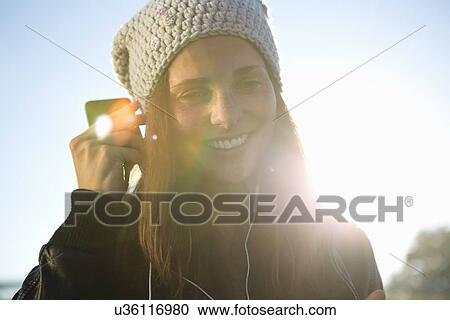 Portrait of young woman wearing earphones listening to music View Large Photo Image Stock Image - Portrait of young woman wearing earphones listening to music. Fotosearch