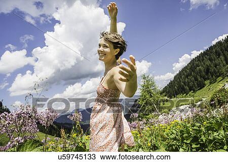 Portrait of young woman with arms up, Tyrol, Austria View Large Photo Image Stock Image - Portrait of young woman with arms up, Tyrol, Austria. Fotosearch