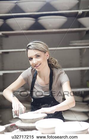 Stock Photography - Potter working on plate at crockery factory. Fotosearch