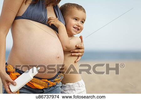 Pregnant mother hugging toddler View Large Photo Image Picture - Pregnant mother hugging toddler. Fotosearch