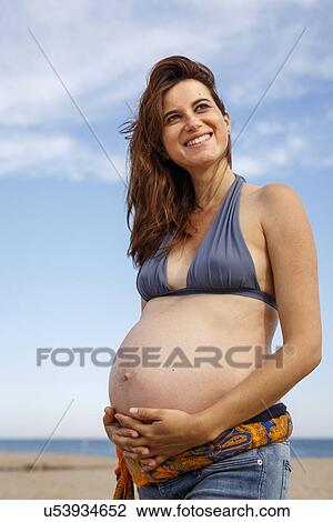 Pregnant woman on beach, hand on stomach View Large Photo Image Stock Image - Pregnant woman on beach, hand on stomach. Fotosearch