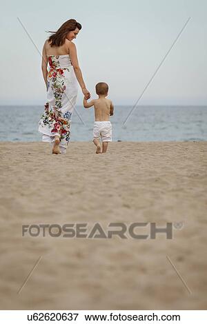 Rear view of mother and toddler walking towards sea View Large Photo Image Stock Photo - Rear view of mother and toddler walking towards sea. Fotosearch