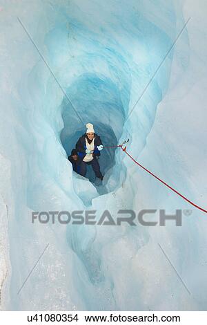 Picture - Rock climbers moving up ice cave Fox Glacier, South Island, New Zealand. Fotosearch