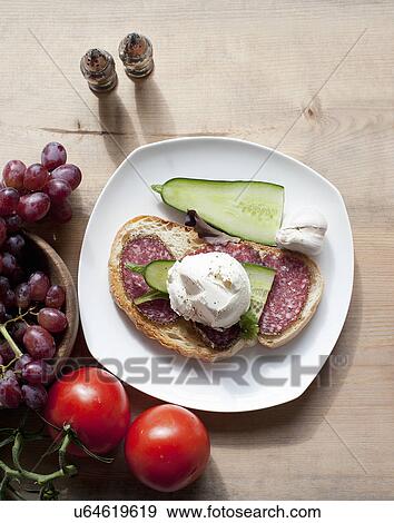 Stock Photo - Salami sandwich with grapes and tomatoes. Fotosearch