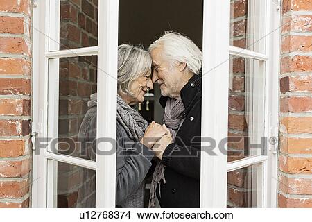 Picture - Senior couple face to face by window. Fotosearch