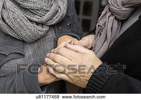 Stock Photo - Senior couple holding hands, close up. Fotosearch