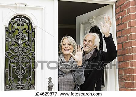 Senior couple waving by front door View Large Photo Image Stock Photo - Senior couple waving by front door. Fotosearch