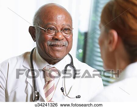 Senior doctor with female patient View Large Photo Image Stock Photograph - Senior doctor with female patient. Fotosearch