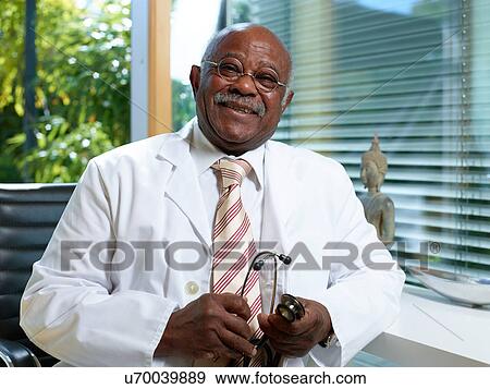 Stock Photo - Senior doctor with stethoscope, wearing lab coat. Fotosearch