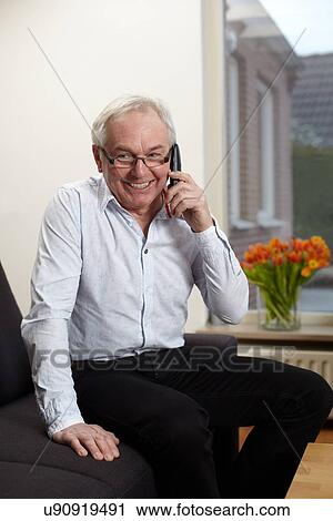 Senior man at home talking on mobile phone View Large Photo Image Stock Image - Senior man at home talking on mobile phone. Fotosearch