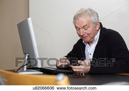 Senior man at home using personal computer View Large Photo Image Stock Photograph - Senior man at home using personal computer. Fotosearch