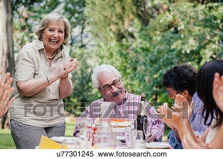 Senior man being presented with cake at birthday party View Large Photo Image Stock Photography - Senior man being presented with cake at birthday party. Fotosearch