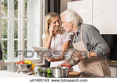 Senior man cooking with daughter, tasting food View Large Photo Image Stock Image - Senior man cooking with daughter, tasting food. Fotosearch