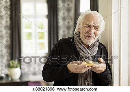 Senior man holding danish pastry View Large Photo Image Stock Photograph - Senior man holding danish pastry. Fotosearch