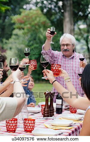 Stock Photograph - Senior man making a toast at family meal. Fotosearch