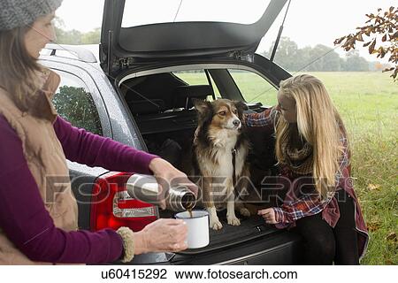 Stock Image - Senior woman and granddaughter with dog. Fotosearch