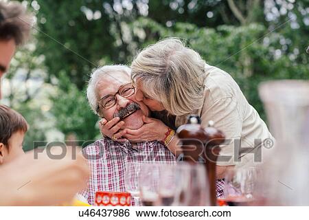Senior woman kissing husband on cheek View Large Photo Image Stock Photograph - Senior woman kissing husband on cheek. Fotosearch