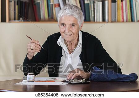 Stock Photograph - Senior woman painting. Fotosearch