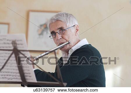 Stock Photo - Senior woman playing flute. Fotosearch