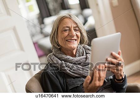 Stock Image - Senior woman with digital tablet. Fotosearch