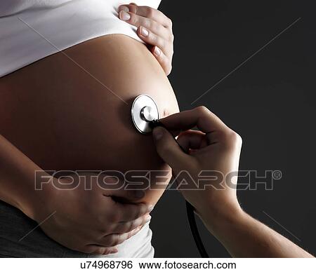 Stock Photograph - Stethoscope on pregnant woman's belly. Fotosearch