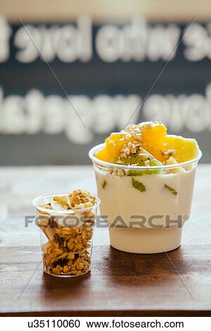 Stock Image - Still life of fruit and yoghurt breakfast and granola. Fotosearch