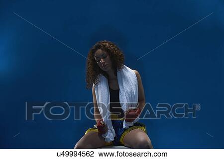 Stock Image - Studio portrait of disappointed female boxer. Fotosearch