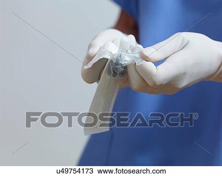 Stock Image - Surgeon opening packet. Fotosearch